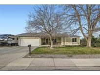 Charming ranch-style home with mature trees, a lush front lawn and two car garage at 10661 W 104Th Ave, Broomfield, CO 80021