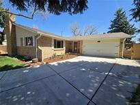 Charming single-Gathering home with brick facade, two-car garage, and a well-maintained front yard at 6238 S Cherry Cir, Centennial, CO 80121
