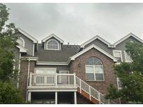 Charming multi-level townhome boasts brick accents and a cozy outdoor deck with stairs at 16366 E Fremont Ave # 11, Aurora, CO 80016