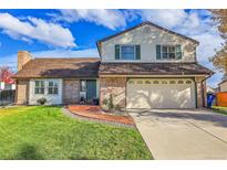 Charming two-story home featuring brick and siding, a two-car garage, and manicured lawn at 7218 S Iris Ct, Littleton, CO 80128