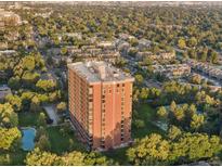 An aerial view shows the apartment building and the surrounding green neighborhood in summer at 1900 E Girard Pl # 608, Englewood, CO 80113