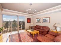 Bright living room with large windows offering scenic views, leather furniture, and wood flooring at 1900 E Girard Pl # 608, Englewood, CO 80113