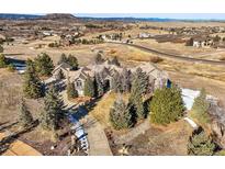 Expansive estate aerial view showcases a beautiful home, mature trees, and a stunning natural landscape at 4749 Starfire Cir, Castle Rock, CO 80104