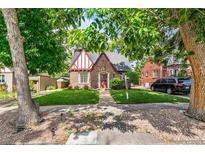 Charming brick Tudor-style home with well-manicured lawn and mature trees at 3055 N Albion St, Denver, CO 80207