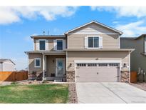 Charming two-story home featuring stone accents, a two-car garage, and a well-manicured lawn at 14836 Jersey Dr, Mead, CO 80542