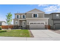 Charming two-story home with a well-manicured lawn and a two-car garage and stone accents at 14836 Jersey Dr, Mead, CO 80542