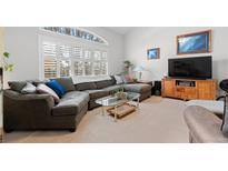 Bright living room features a large sectional couch and a window with plantation shutters at 4023 E Geddes Cir, Centennial, CO 80122
