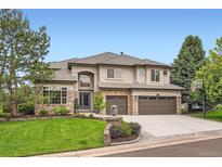 Beautiful two-story home with stone accents, mature trees, and a well-manicured lawn at 9445 Aspen Hill Cir, Lone Tree, CO 80124