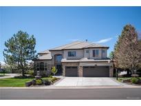 Stunning two-story home featuring stone accents, a three-car garage, and beautifully landscaped front yard at 9445 Aspen Hill Cir, Lone Tree, CO 80124