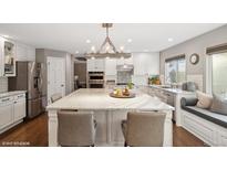 Spacious kitchen with an oversized island, stainless steel appliances, and a window bench seat at 9445 Aspen Hill Cir, Lone Tree, CO 80124