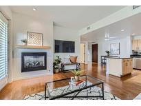 Bright living room features hardwood floors, fireplace, and a view into the kitchen at 3601 Arapahoe Ave # 102, Boulder, CO 80303