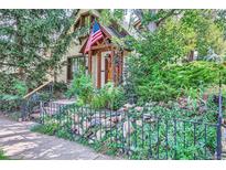 Charming cottage-style home with landscaped front yard and American flag flying at the entrance at 1928 S Washington St, Denver, CO 80210
