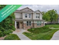 Charming two-story townhome with a stone and siding exterior, walkway, and well-maintained landscaping at 9758 Laredo St # 22D, Commerce City, CO 80022