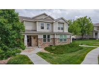 Charming two-story townhome featuring stone accents and a well-manicured lawn and walkway at 9758 Laredo St # 22D, Commerce City, CO 80022
