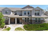Charming townhome with stone accents, well-kept landscaping, and inviting front porches at 9758 Laredo St # 22D, Commerce City, CO 80022
