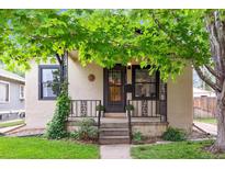 Charming bungalow featuring a covered front porch, black iron railings, and fresh landscaping at 2676 S Lincoln St, Denver, CO 80210