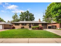 Charming single-story home featuring a well-manicured lawn, mature trees, and inviting curb appeal at 1840 E 84Th Ave, Denver, CO 80229