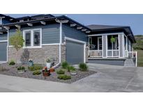 Charming two-story home with a gray exterior, stone accents, well-maintained landscaping, and inviting front porch at 527 Felicity Loop, Castle Rock, CO 80109