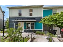 Inviting townhouse with covered porch, chairs, and colorful exterior accents at 2829 W 53Rd Ave # 104, Denver, CO 80221