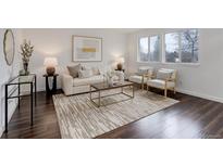 Bright living room featuring wood floors, a stylish rug, sofa, chairs, and large windows at 1777 Willow St, Denver, CO 80220