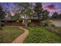 Charming brick home with a well-manicured lawn and a brick pathway leading to the entrance at 3285 Balsam St, Wheat Ridge, CO 80033
