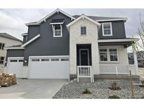 Charming home featuring a two-car garage, modern gray siding, stone accents, and well-maintained landscaping at 5591 Farrier Pt, Castle Rock, CO 80104