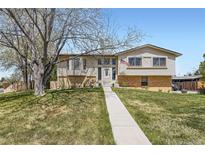 Charming two-story home with a well-manicured lawn and mature trees at 6477 W Clifton Pl, Littleton, CO 80128