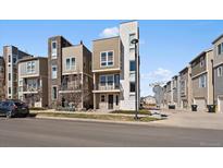 Modern townhouse boasts a stylish exterior with a combination of stone and siding details and small front yard at 574 E Hinsdale Ave, Littleton, CO 80122