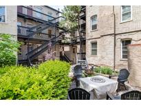 Charming courtyard with fire pit, seating area, and lush landscaping at 1210 E Colfax Ave # 302, Denver, CO 80218