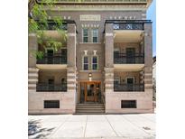 Apartment building exterior featuring balconies with iron railings and intricate brick and stone design at 1210 E Colfax Ave # 302, Denver, CO 80218