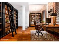 Office with wooden floors, bookshelves and a desk by the window at 1210 E Colfax Ave # 302, Denver, CO 80218