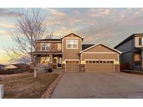 Inviting two-story home with a three-car garage and a covered porch, perfect for suburban living at 2776 Badlands Ct, Castle Rock, CO 80109