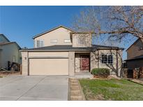 Charming two-story home featuring a two-car garage, well-maintained lawn, and mature trees at 2875 S Tower Way, Aurora, CO 80013