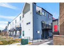 Modern townhome featuring a metal and stucco facade, multiple balconies, and well-maintained landscaping at 3050 Wilson Ct # 1, Denver, CO 80205