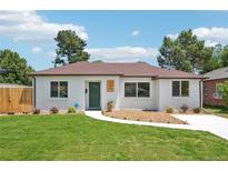Charming home featuring a well-manicured lawn and a classic white brick exterior with a lovely brown roof at 2230 Niagara St, Denver, CO 80207