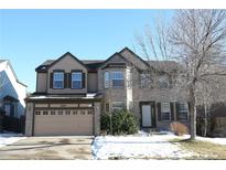 Two-story house with beige and brick exterior, attached garage, and landscaping at 18874 E Ida Ave, Aurora, CO 80015
