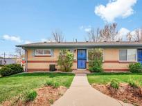 Charming brick home with a well-manicured lawn and a welcoming blue front door and walkway at 4201 Shoshone St, Denver, CO 80211