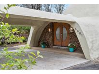 Unique geodesic home entrance with stone accents, double doors, and covered carport at 6681 S Abilene Way, Centennial, CO 80111