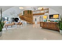 Spacious living room features a unique stone pillar, spiral staircase, and modern furnishings at 6681 S Abilene Way, Centennial, CO 80111