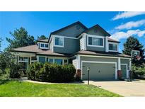 Charming two-story home boasts a manicured lawn, attached garage, and basketball hoop at 10421 Kennemere Ln, Parker, CO 80134