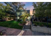 Inviting home featuring a well-maintained lawn, mature trees, and a charming walkway leading to the front door at 1057 N Emerson St # B, Denver, CO 80218