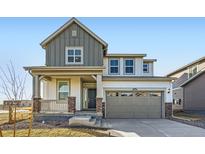 Charming two-story home showcasing a covered porch with stone accents and a neutral color palette at 4858 Astor Pl, Brighton, CO 80601