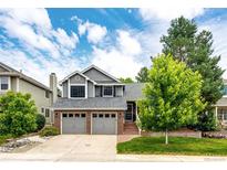 Charming home with a two-car garage, brick accents, and mature trees in a well-manicured front yard at 9846 Spring Hill Ln, Highlands Ranch, CO 80129