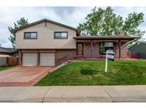 Charming two-story home featuring a brick and siding exterior, attached garage, and well-manicured front lawn at 10154 W Hawaii Pl, Lakewood, CO 80232