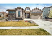 Beautifully landscaped two-story home with stone accents and a well-manicured lawn at 16392 Spanish Peak Way, Broomfield, CO 80023