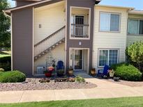 Charming condo featuring well-maintained landscaping with flowers, shrubs, and a cozy seating area at 5455 S Dover S St # 102, Littleton, CO 80123