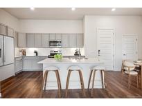 Bright kitchen features gray cabinets, stainless appliances, and an island with seating at 485 Interlocken Blvd # 102, Broomfield, CO 80021