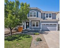 Charming two-story home with a covered porch, landscaped yard, and a two car garage on a sunny day at 1963 Hogan Ct, Castle Rock, CO 80109