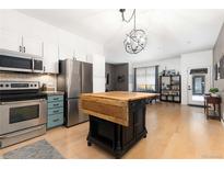 Open kitchen featuring stainless appliances, kitchen island, and modern lighting fixtures at 3225 Blake St # 6, Denver, CO 80205