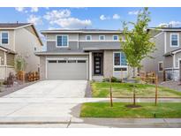 Charming two-story home with grey exterior, neat landscaping, and a concrete driveway at 24717 E 40Th Ave, Aurora, CO 80019